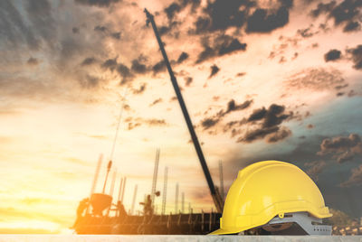 Yellow construction site against sky during sunset