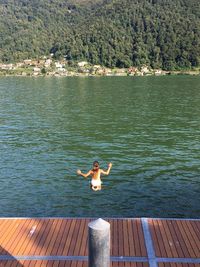 Rear view of person on pier over lake