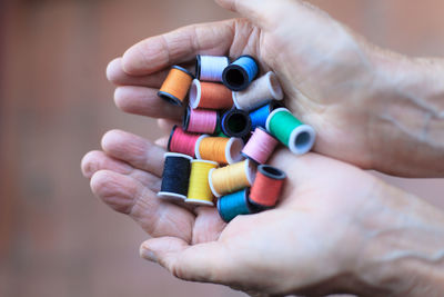 Cropped hands of person holding threads