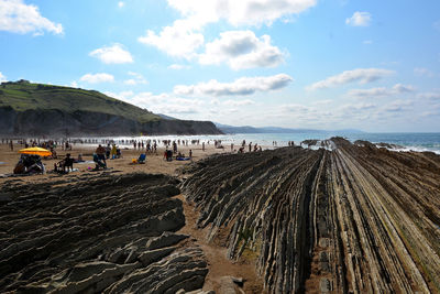 Group of people on beach against sky