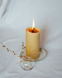 Close-up of illuminated candle on table