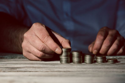 Close-up of hand holding stack of objects on table