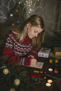 Woman in illuminated christmas tree