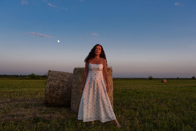 Woman standing on field against sky