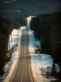 Road amidst trees during winter