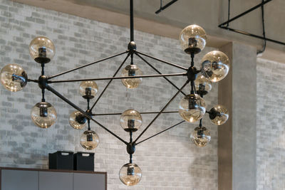 Low angle view of illuminated pendant light hanging from ceiling