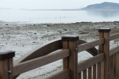 Wooden posts on beach against sky