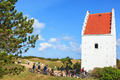 Young people on a bike trip to the sand-covered church in skagen