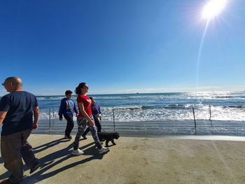 People on beach against blue sky