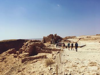 People on desert against sky
