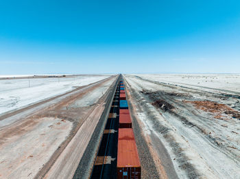 Cargo train passing by the desert nevada, usa near salt flats.