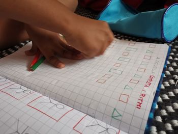 High angle view of child writing in book