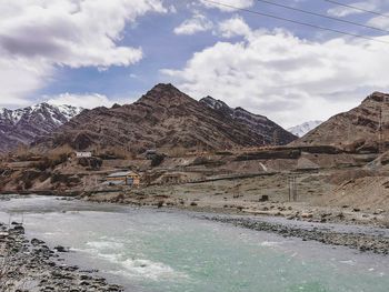 Scenic view of land and mountains against sky