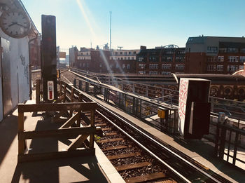 Railroad tracks amidst buildings in city against sky