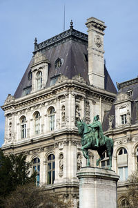 Low angle view of statue of historic building against sky