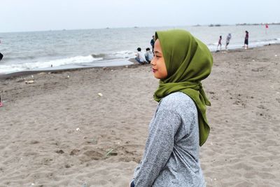 Side view of woman standing at beach