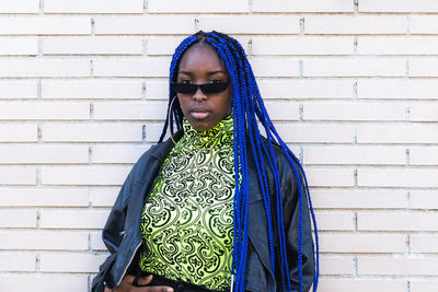 Portrait of woman standing against wall