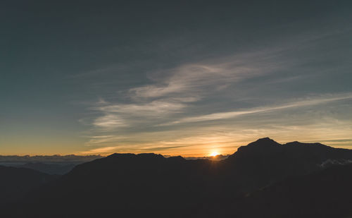 Scenic view of silhouette mountains against sky during sunset