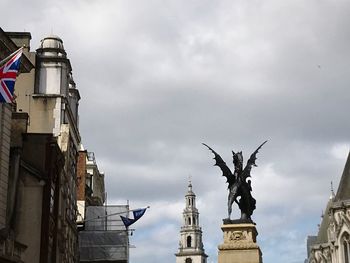 Low angle view of statue of building against cloudy sky