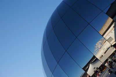 Low angle view of modern building against blue sky