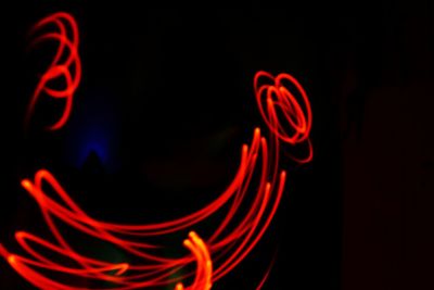 Close-up of illuminated red light against black background