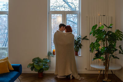 Rear view of woman looking through window