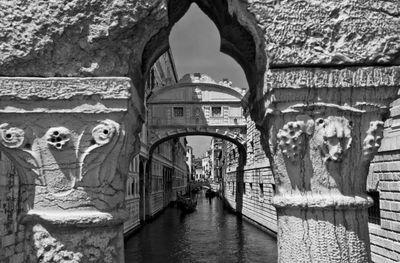 Bridge of sighs over canal amidst buildings