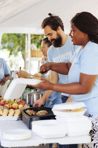 Side view of friends having food at home