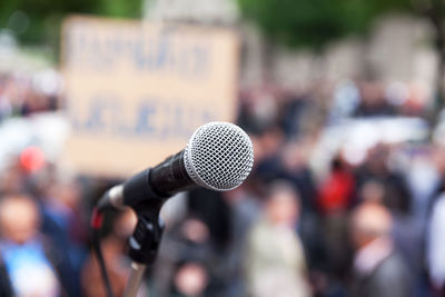 Close-up of microphone against crowd in city