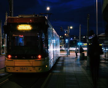 Train at railroad station platform at night