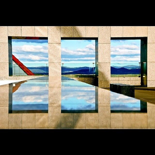 window, glass - material, indoors, architecture, built structure, sky, transparent, blue, water, day, reflection, cloud, cloud - sky, no people, glass, building exterior, sea, nature, looking through window