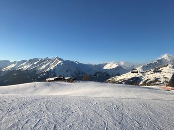 Scenic view of snowcapped mountains against clear blue sky