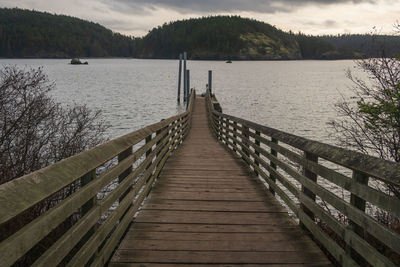 Landscape of wooden pier over water with land in the distance at rosario head  in washington