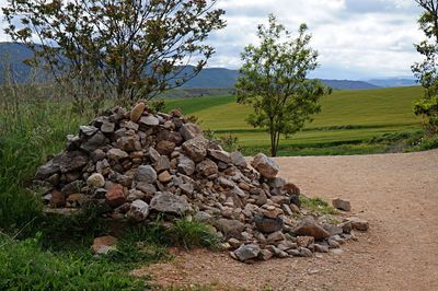 Stack of rocks on field against sky