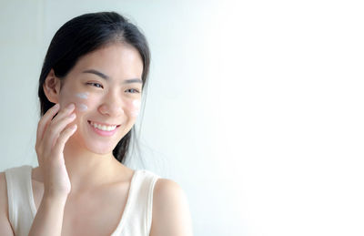 Portrait of young woman against white background