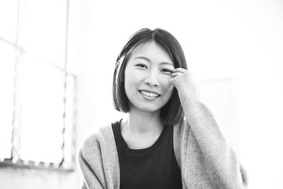 Portrait of young woman standing against wall