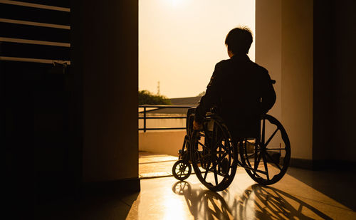 Rear view of silhouette man sitting in bus