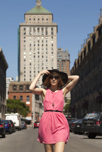 Woman in pink dress walking in city