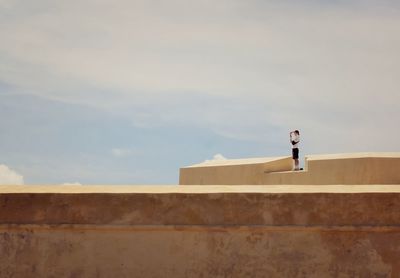 Full length of man standing on building against sky