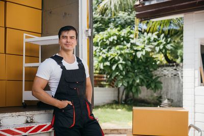 Portrait of young man standing against building