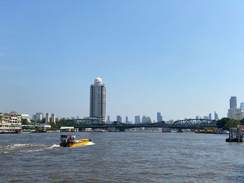 Ferry boat in sea against buildings in city