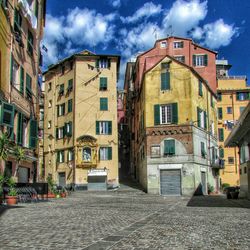 Buildings in city against cloudy sky