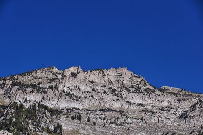 Low angle view of mountain against clear blue sky