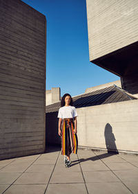 Portrait of woman standing against building