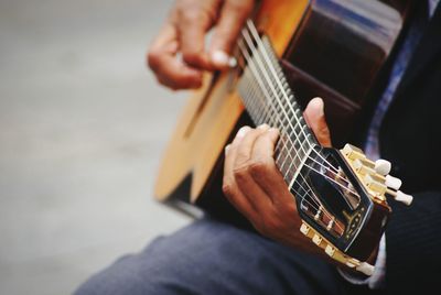 Midsection of street musician playing guitar