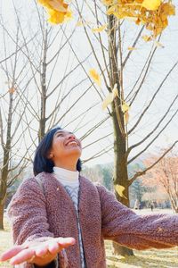 Low angle view of woman standing on branch