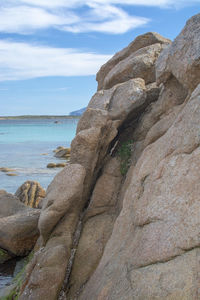 Rock formation on beach against sky