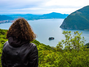 Rear view of woman against lake and sky