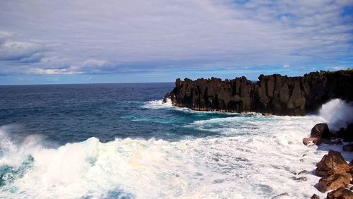 Scenic view of rocks in sea against sky