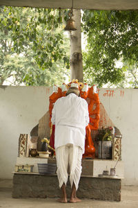 Rear view of man praying god in temple